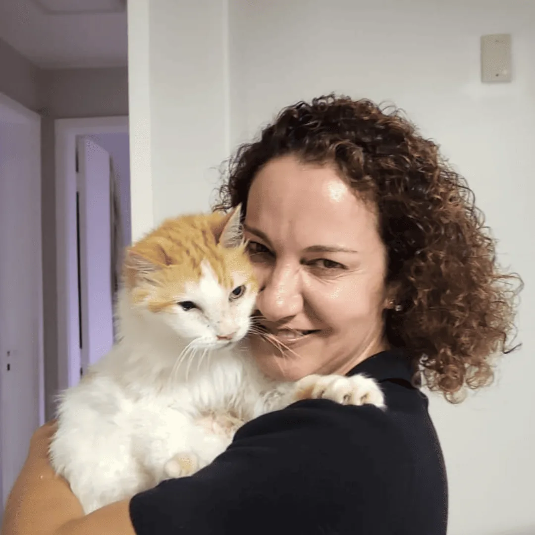 Dra. Nanci Diniz abraçando um gato branco e laranja