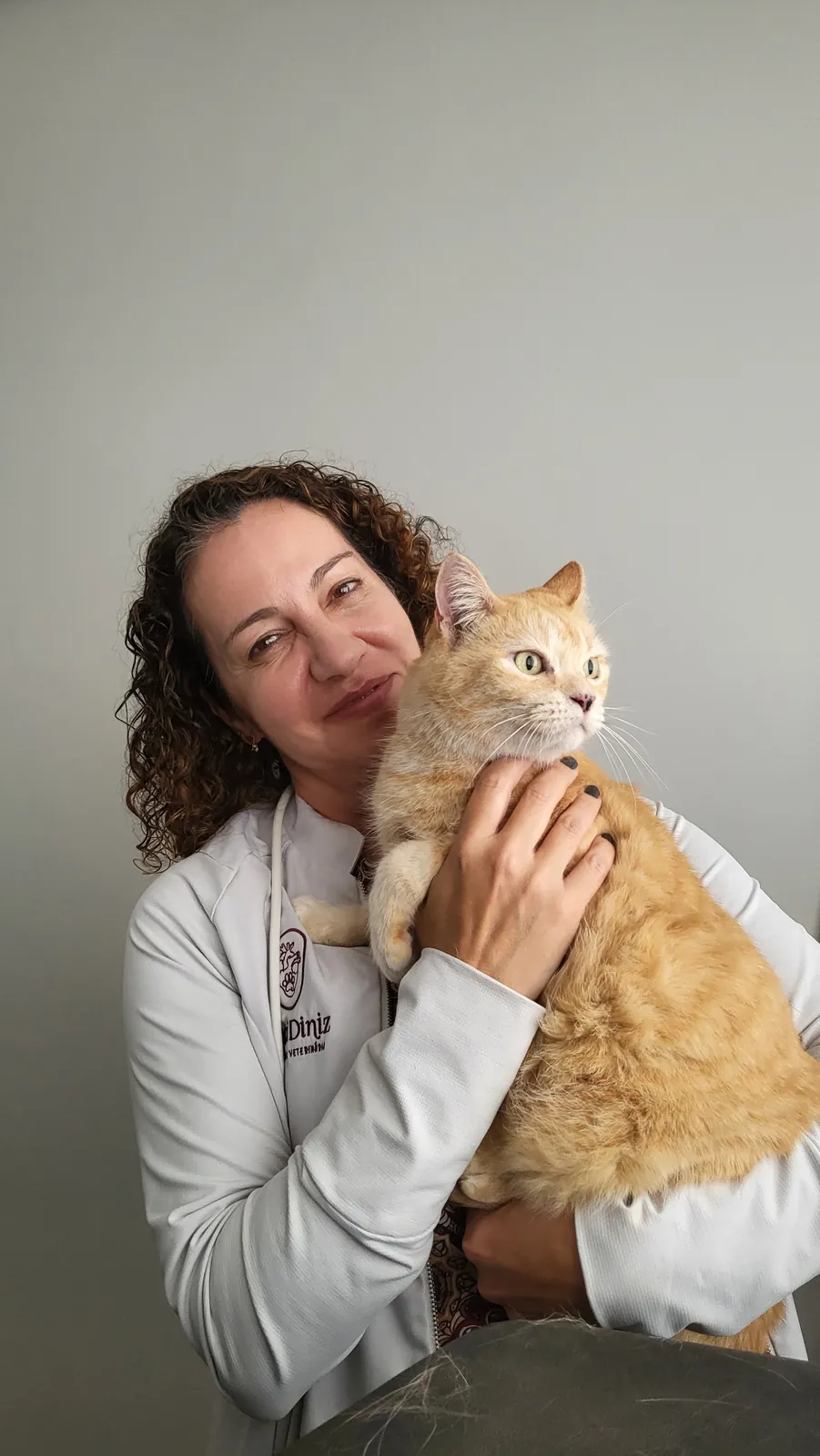 Dra. Nanci Diniz abraçando um gato laranja